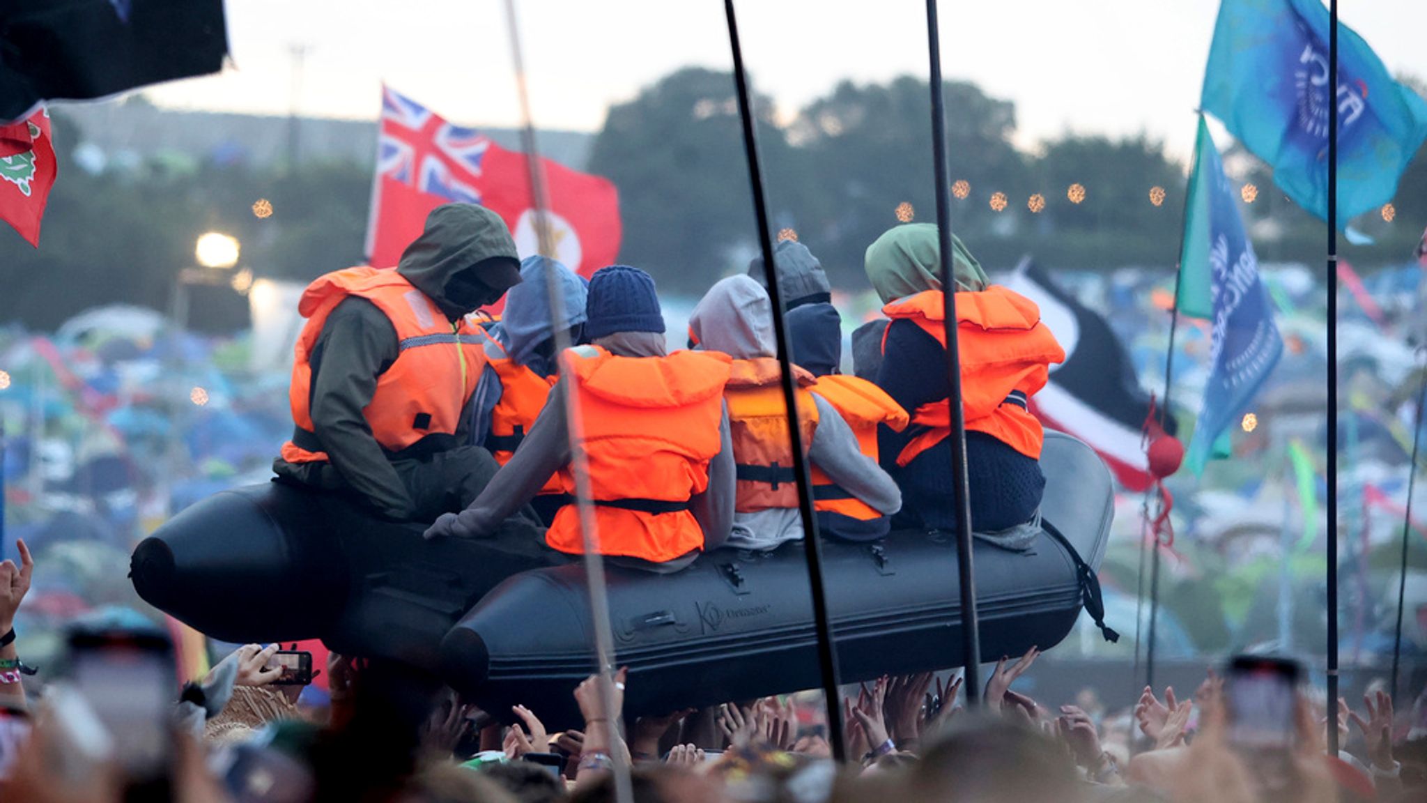 Banksy joga barco de imigrantes na plateia de Glastonbury